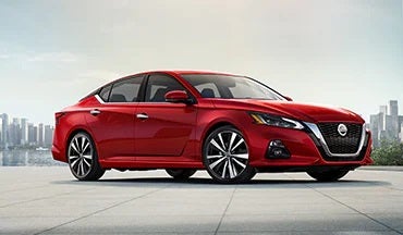 2023 Nissan Altima in red with city in background illustrating last year's 2022 model in Tony Serra Highland Nissan in Highland MI