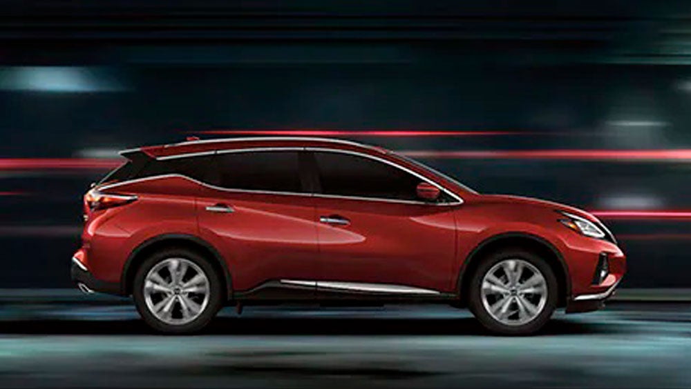 2023 Nissan Murano shown in profile driving down a street at night illustrating performance. | Tony Serra Highland Nissan in Highland MI